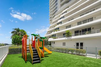 Outdoor childrens playground with slide and artificial turf